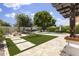 Lush backyard with artificial turf, pool, mature trees, and relaxing hammock at 5211 W Wikieup Ln, Glendale, AZ 85308