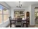 Dining area with wood table, views of the backyard, and modern light fixture at 5211 W Wikieup Ln, Glendale, AZ 85308