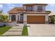 Inviting two-story home with a well-maintained yard and a two-car garage with a pathway to the front door at 5211 W Wikieup Ln, Glendale, AZ 85308