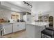Bright kitchen with white cabinets, island with seating, stainless steel appliances, and open view to dining area at 5211 W Wikieup Ln, Glendale, AZ 85308