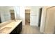 Modern bathroom with dual vanity, walk-in shower, and walk-in closet entrance at 5645 S 253Rd Ave, Buckeye, AZ 85326