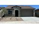 Charming single-story home featuring a tile roof, two-car garage, and low maintenance desert landscaping at 5645 S 253Rd Ave, Buckeye, AZ 85326