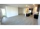 Open-concept living room features wood-look tile floors and flows into a modern kitchen with stainless steel appliances at 5645 S 253Rd Ave, Buckeye, AZ 85326