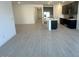 Open-concept living room features wood-look tile floors and flows into a modern kitchen with stainless steel appliances at 5645 S 253Rd Ave, Buckeye, AZ 85326