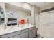 Bright bathroom featuring double sinks, spacious shower, and vanity with gray cabinets offering ample storage space at 5724 N 108Th Ave, Phoenix, AZ 85037