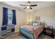 Bedroom featuring bright bedding, a ceiling fan, a window with curtains, and side table at 5724 N 108Th Ave, Phoenix, AZ 85037