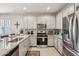 Bright kitchen features gray cabinets, stainless steel appliances, and granite countertops for modern living at 5724 N 108Th Ave, Phoenix, AZ 85037