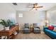 Cozy living area with comfortable seating, a ceiling fan, and natural light from the windows at 5724 N 108Th Ave, Phoenix, AZ 85037