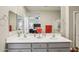 Bathroom with double sinks, gray cabinets, and mirrors that opens to the main bedroom at 5724 N 108Th Ave, Phoenix, AZ 85037