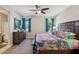 Inviting main bedroom with ceiling fan, large bed with colorful quilt, and natural light at 5724 N 108Th Ave, Phoenix, AZ 85037