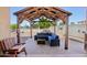 Outdoor seating area featuring a wooden gazebo, cushioned seating, and a view of the yard at 5724 N 108Th Ave, Phoenix, AZ 85037