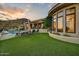 Beautiful backyard featuring a pool, patio with lounge chairs, grass, and the exterior of a modern-style home at 6432 E El Sendero Rd, Carefree, AZ 85377