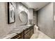 Stylish powder room featuring elegant wallpaper, a round mirror, and a sleek marble countertop at 6432 E El Sendero Rd, Carefree, AZ 85377