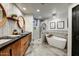 Modern bathroom boasting dual vanities, a stylish tub, and a glass-enclosed shower with tile accents at 6432 E El Sendero Rd, Carefree, AZ 85377