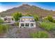 Desert modern home with a mountain backdrop, featuring a second-story balcony and mature trees at 6432 E El Sendero Rd, Carefree, AZ 85377