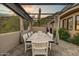 Covered patio showcasing a large dining table and desert views with lush, drought-resistant landscaping at 6432 E El Sendero Rd, Carefree, AZ 85377