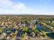 Expansive aerial view of the residential area showcasing community lakes, well-maintained streets, and lush greenery at 6907 W Monona Dr, Glendale, AZ 85308