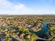 Aerial view showcases a residential area surrounded by water and lush vegetation at 6907 W Monona Dr, Glendale, AZ 85308