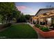 Well-manicured backyard boasts a spacious patio, lush lawn, and privacy landscaping perfect for outdoor enjoyment at 6907 W Monona Dr, Glendale, AZ 85308