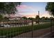 Scenic backyard view features a tranquil lake reflecting a colorful sky, and a secure fence at 6907 W Monona Dr, Glendale, AZ 85308