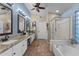 Bright bathroom featuring double vanity, separate shower, and bathtub at 6907 W Monona Dr, Glendale, AZ 85308