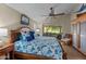 Bright bedroom with blue patterned bedding, ceiling fan, and large window view at 6907 W Monona Dr, Glendale, AZ 85308
