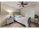 Cozy bedroom featuring a ceiling fan, natural light from a bright window, and a comfortable wrought iron bed frame at 6907 W Monona Dr, Glendale, AZ 85308