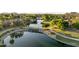 Scenic aerial view of a community pond, walking paths, and lush landscaping creating a tranquil environment at 6907 W Monona Dr, Glendale, AZ 85308