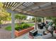 Relaxing covered patio with stylish furniture, a fire pit, and a decorative planter, perfect for outdoor living at 6907 W Monona Dr, Glendale, AZ 85308