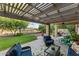 Inviting covered patio features comfortable seating, a ceiling fan, and views of the beautifully landscaped backyard at 6907 W Monona Dr, Glendale, AZ 85308