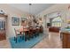 Elegant dining room features chandelier, a wooden table with six chairs, and blue rug at 6907 W Monona Dr, Glendale, AZ 85308