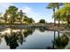 Picturesque community pond with a waterfall feature, mature landscaping, and serene reflections on the water at 6907 W Monona Dr, Glendale, AZ 85308