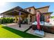 Gorgeous backyard with covered patio, hot tub, artificial grass, and privacy landscaping, perfect for outdoor enjoyment at 7123 W Andrea Dr, Peoria, AZ 85383