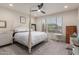 Well-lit bedroom featuring a four-poster bed, neutral carpeting, and a ceiling fan at 7123 W Andrea Dr, Peoria, AZ 85383