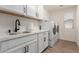 Bright laundry room features white cabinets, quartz counters, matte black hardware, and a modern washer and dryer at 7123 W Andrea Dr, Peoria, AZ 85383