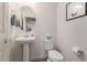 Stylish powder room showcasing a pedestal sink, a round mirror, and minimalist decor at 7123 W Andrea Dr, Peoria, AZ 85383