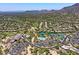 Breathtaking aerial view of the community showcasing the pool, tennis courts, golf course, and desert landscape at 7128 E Bramble Berry Ln, Scottsdale, AZ 85266