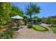 Charming backyard with lush greenery, comfortable seating, and a putting green for entertainment at 7128 E Bramble Berry Ln, Scottsdale, AZ 85266