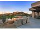 A luxurious outdoor lounge with firepit seating, overlooking stunning views of mountains and desert landscape at 7128 E Bramble Berry Ln, Scottsdale, AZ 85266