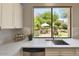 Bright kitchen with backyard views, stainless dishwasher, white cabinets, and quartz countertop at 7128 E Bramble Berry Ln, Scottsdale, AZ 85266