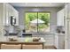Modern kitchen with white cabinets, stainless appliances, and a view of the landscaped backyard at 7128 E Bramble Berry Ln, Scottsdale, AZ 85266