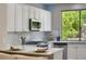 Bright kitchen featuring white cabinets, modern appliances, and a large window with a backyard view at 7128 E Bramble Berry Ln, Scottsdale, AZ 85266