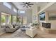 Bright living room with a fireplace, large windows, ceiling fan, and modern decor at 7128 E Bramble Berry Ln, Scottsdale, AZ 85266