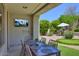 Relax and entertain on the covered patio with a TV, dining table, and view of the backyard putting green at 7128 E Bramble Berry Ln, Scottsdale, AZ 85266