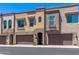 Street view of modern townhomes with attached garages, neutral stucco, and arched entryways at 7492 E Via De Luna Dr, Scottsdale, AZ 85255
