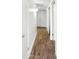 Clean hallway with wood-look tile floors and neutral walls and trim, plus lighting at 7730 W Mulberry Dr, Phoenix, AZ 85033