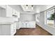 Bright kitchen featuring white cabinetry, an island with a sink, and a view to the front yard at 7730 W Mulberry Dr, Phoenix, AZ 85033