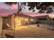 Desert backyard with an open patio, desert landscaping, outdoor seating, and a firepit, under a colorful twilight sky at 8132 E Onza Ave, Mesa, AZ 85212