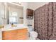 Bright bathroom featuring vanity, toilet, and a brown shower curtain at 8132 E Onza Ave, Mesa, AZ 85212