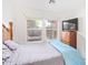 Comfortable bedroom with two windows, light colored walls, and a dresser with a television on top at 8132 E Onza Ave, Mesa, AZ 85212
